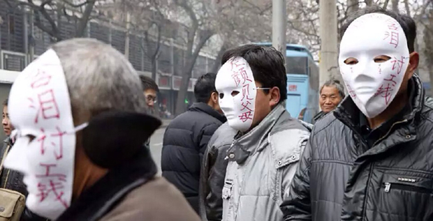 西安农民工带面具街头讨薪 包工头失联无颜见