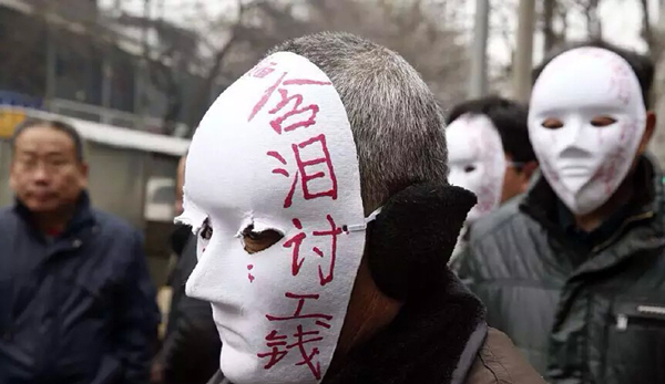 西安农民工带面具街头讨薪 包工头失联无颜见