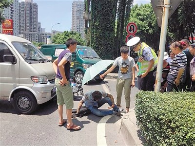 摩托司机被撞躺路边 好心路人帮他遮阳(图)▏摩