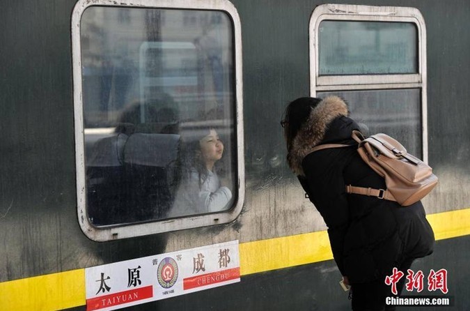 春运一幕:母亲火车站送别5岁女儿 隔窗双双落