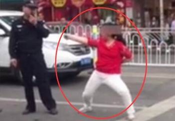 女子被骗一百当街掀衣跳舞 警察劝说无效强行抬走