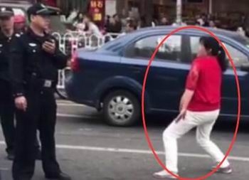 女子被骗一百当街掀衣跳舞 警察劝说无效强行抬走