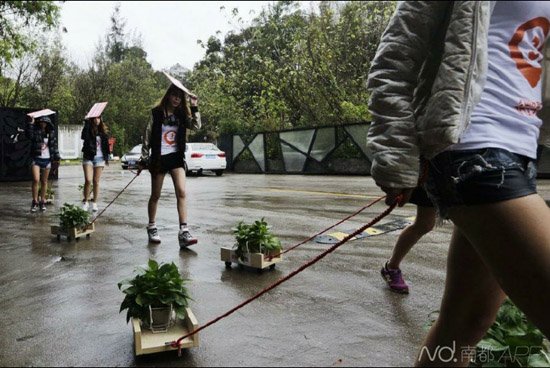 下雨天美女穿小背心在广州红砖厂宣传植树