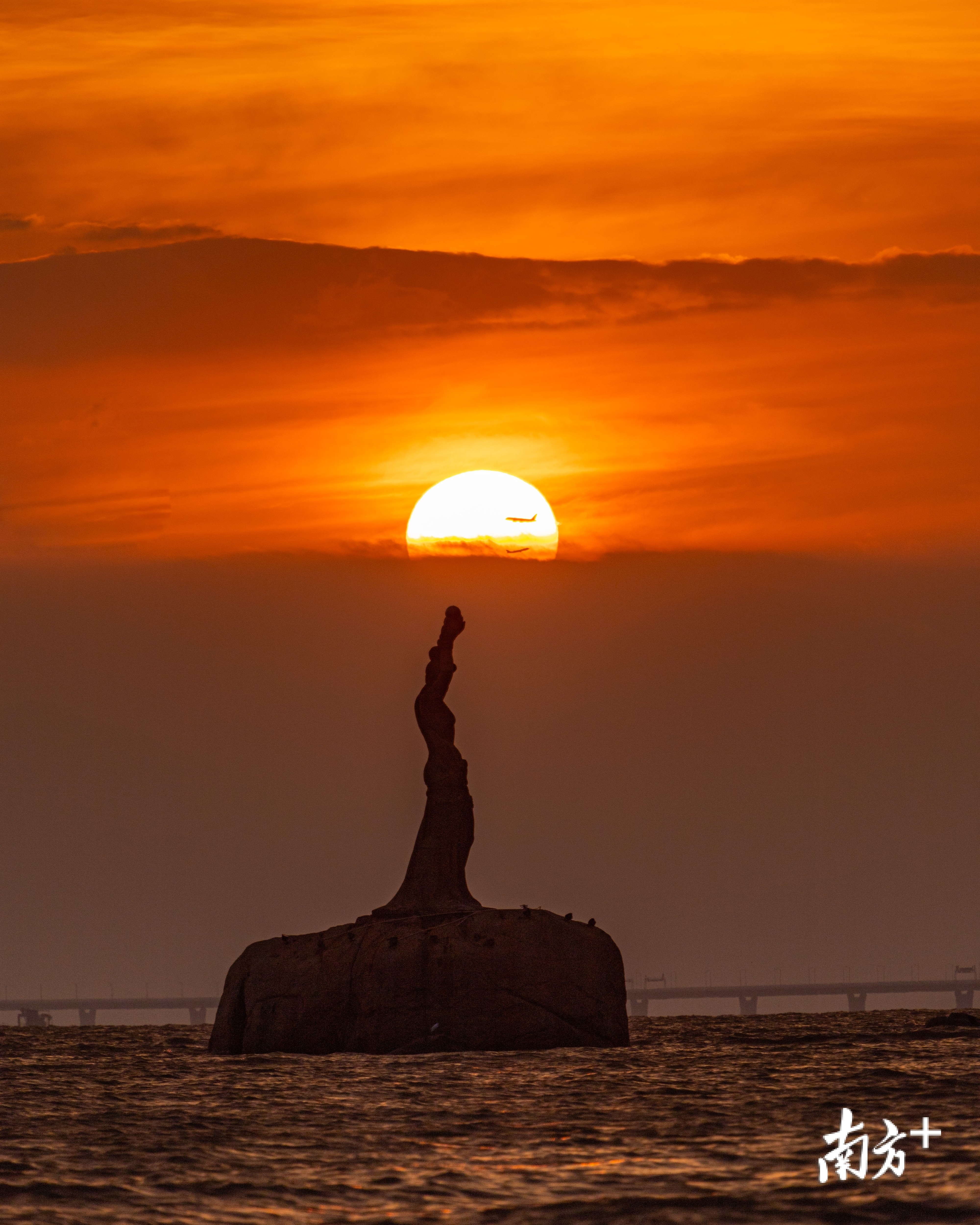9月26日早上，珠海渔女日出，飞机掠过太阳。 Gerrard 摄