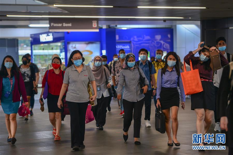 10月5日,在马来西亚吉隆坡,人们戴着口罩走在地铁站内.