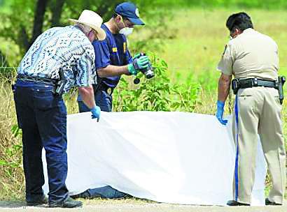 德克萨斯的警察和调查人员为偷渡不成反送命的死者盖上白布