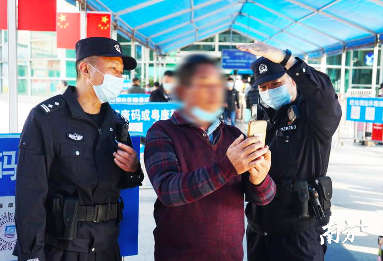 民警辅助旅客使用脸部识别系统。