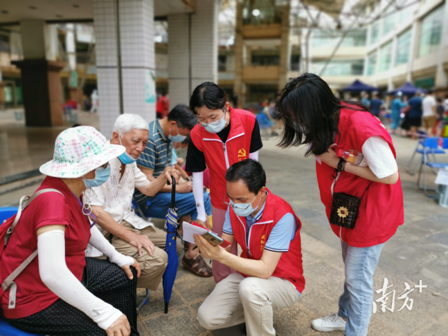 税务志愿者在佛山市南海区花苑社区一线协助开展核酸检测工作，耐心为老年群体进行信息登记。