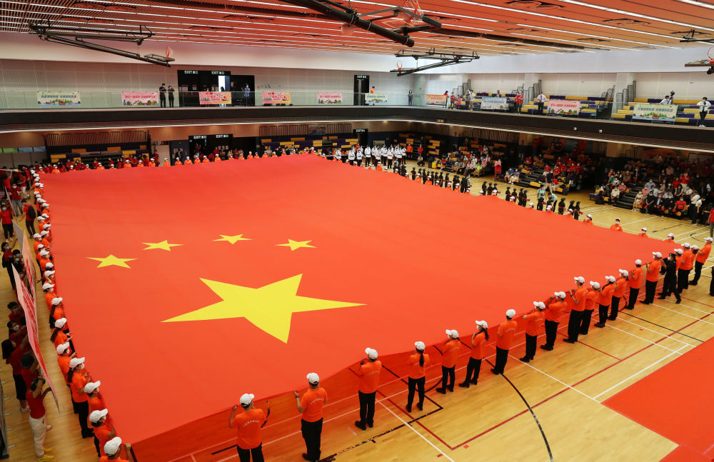 7月1日，在香港坑口体育馆，香港市民展示大型国旗。新华社记者 李钢 摄