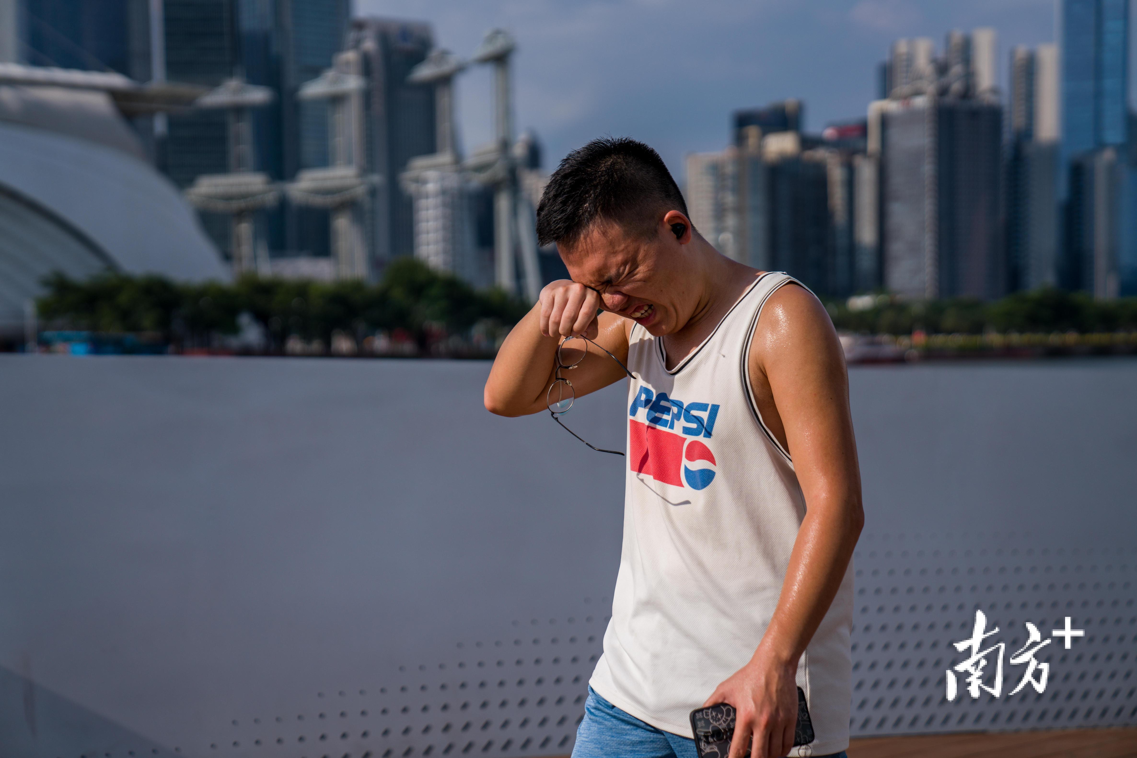 海心桥上，一位男子摘下眼镜擦拭眼睛里的汗水。南方日报记者 徐昊 摄
