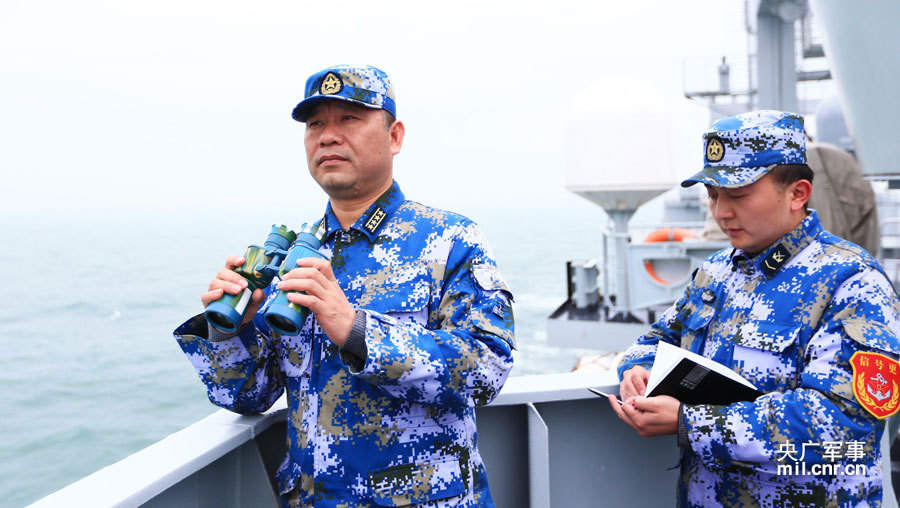 海上指挥员,东海舰队某作战支援舰支队支队长董焱(左)正在观察海上